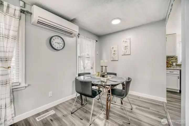 Cozy dining area with modern lighting, natural light, and convenient access to kitchen.