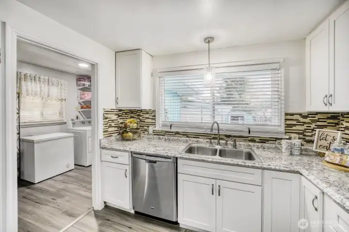 Functional kitchen layout with ample storage and convenient access to laundry area.