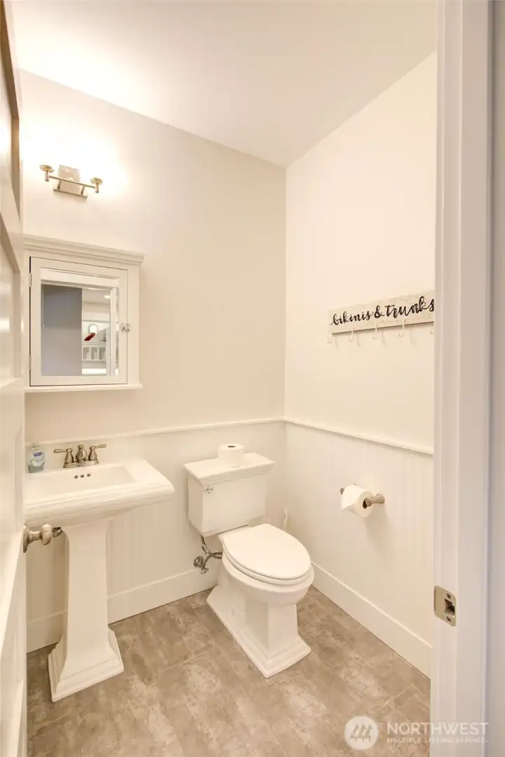 Guest and hot tubbers have access to this powder bath off the media room. Wainscotting helps keep things charming and durable.