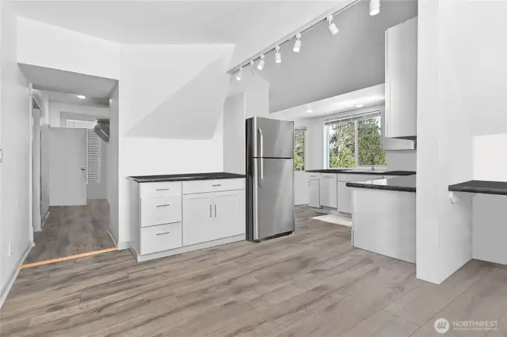 High ceilings and an open concept layout, this remodeled upstairs unit shows beautifully with hard surface floors, a wrap-around kitchen and upgraded lighting.