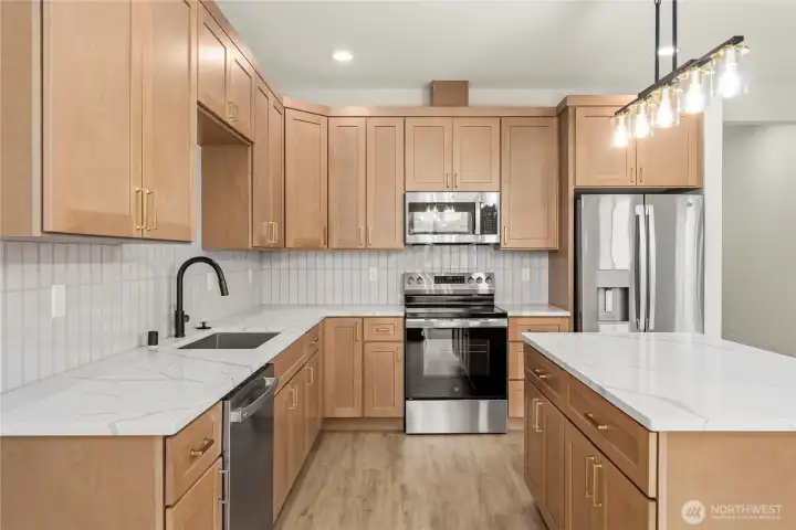 Beautiful kitchen with quartz counters and tile backsplash. Beautiful kitchen with quartz counters and tile backsplash.