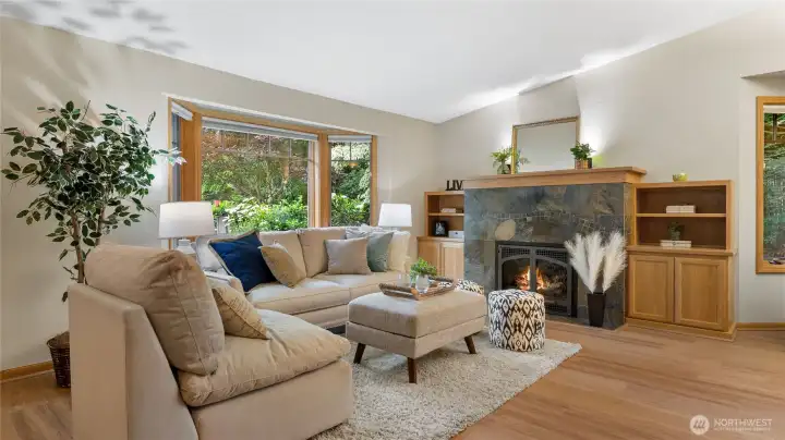 The other bay window offers views to the front yard. A gas fireplace with custom slate surround creates an inviting ambience. Built-in shelving and storage surrounds the fireplace.