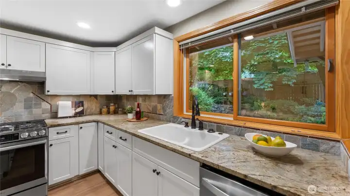 The Andersen wood window with views to the rear yard makes doing dishes a more pleasant experience.