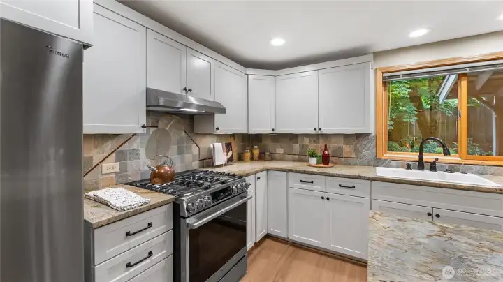 Dual fuel range with electric oven for even cooking and gas burners on cooktop. The lazy susan cabinet can be seen in the corner.