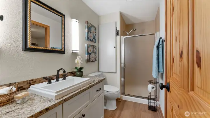 The main floor 3/4 bath is accessed from both the hall and the main floor bedroom through a pocket door.