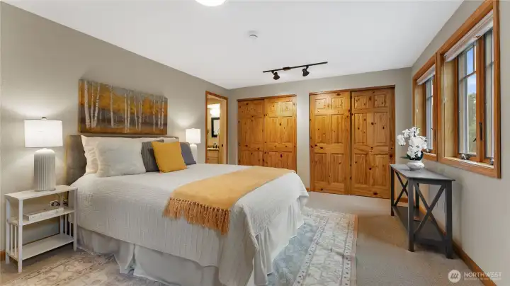 Another view of the primary bedroom. Knotty pine doors are found throughout the home and add to the Northwest charm.