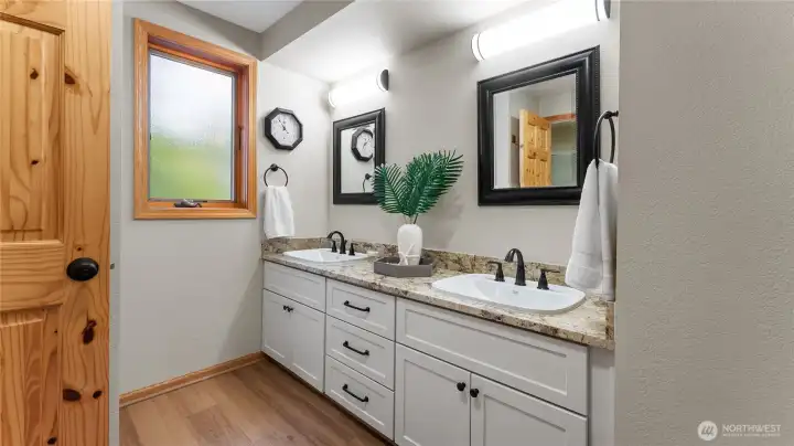 New granite counters, sinks and fixtures adorn the primary bathroom. New luxury plank flooring was installed here as well.