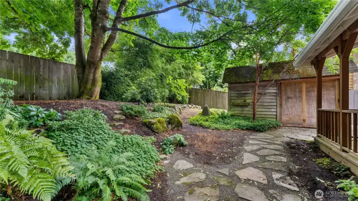 Flagstones create a pathway through the rear yard to the storage shed.