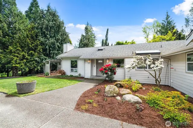 Charming curb appeal with a spacious driveway and lush landscaping.
