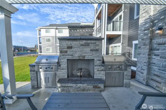 Community patio has natural gas fireplace, two gas grills, tables and chairs.