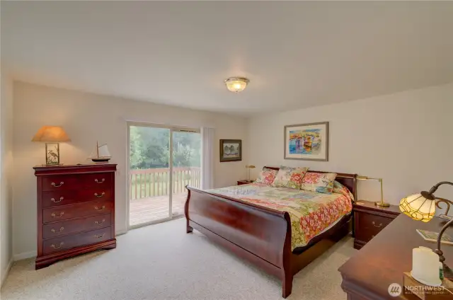 Main floor primary bedroom with walk in closet and access to the south facing rear deck.