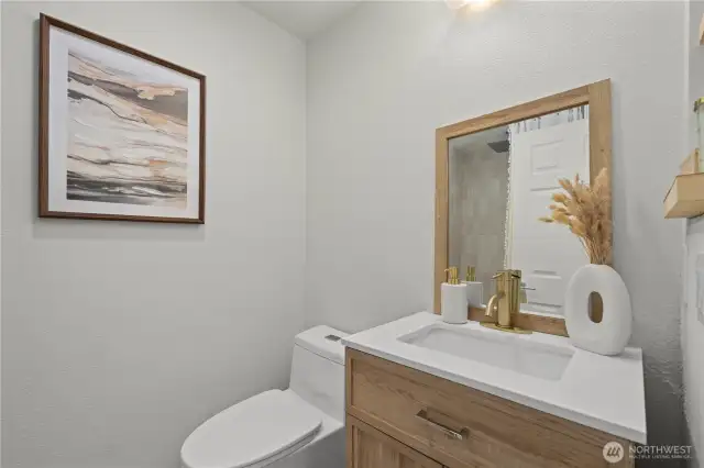 Remodeled primary bathroom with Bedrosian tile surround (tiled to ceiling), quartz countertop, LVP flooring and modern fixtures + mirror.
