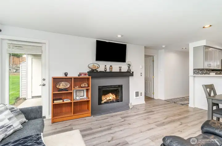 Living room with wood burning stove.  Mounted TV remains with unit