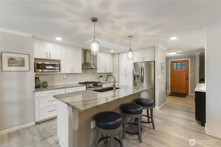 The 2-years new updated kitchen has custom cabinets, new appliances, a breakfast bar for those quick meals, pendent AND can lighting
