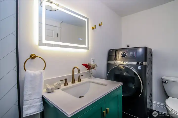 Main floor 3/4 bath has a combo washer/dryer unit.