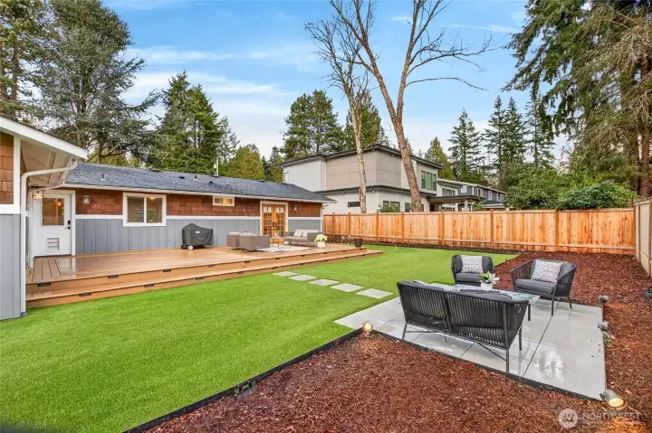 Bonus backyard hardscaped area perfect for hot tub pad or additional seating