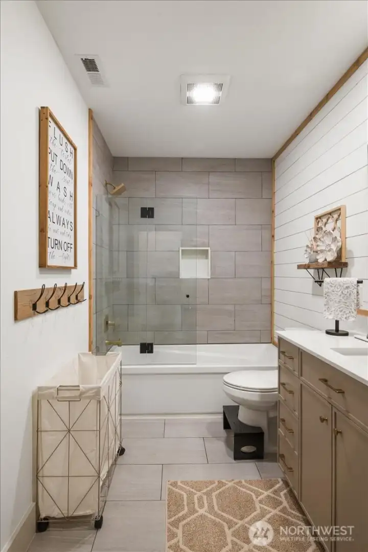 Beautifully appointed main bath with exquisite tile and shiplap detail