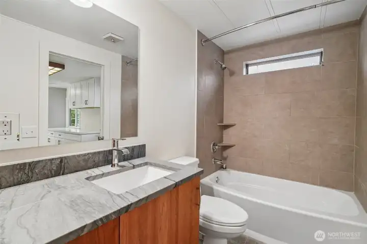 Main house guest bathroom with quarts and tile suround.