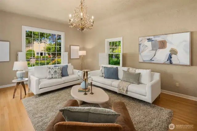 Sunken living room with high coved ceilings, wood floors, picture window and gas fireplace.