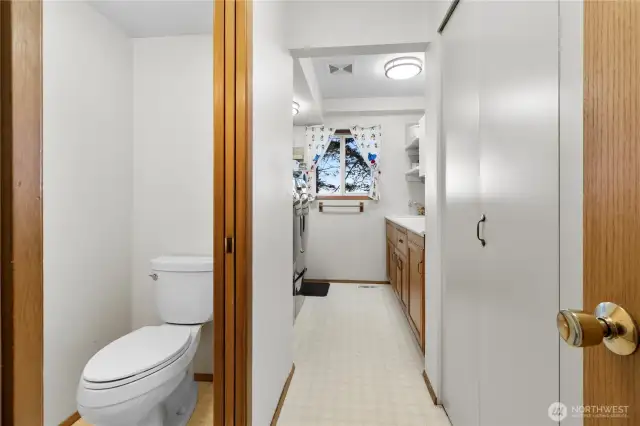 Utility room with a pocket door to a half bath.