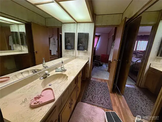 Standing on the other side of your primary bath with a view of another mirrored closet to the right