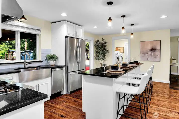 The countertop on the fabulously large island is granite. And just look at the size of that stainless sink!