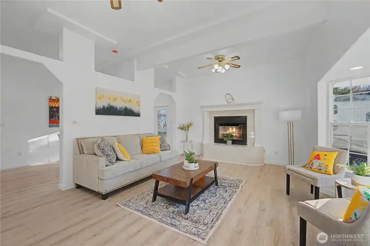 Natural light pours through big windows into the cozy living room, creating an inviting space for relaxation.