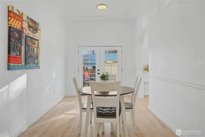 Elegant and light-filled formal dining room boasting bright, airy vibes with classic French doors that flood with space with natural light.