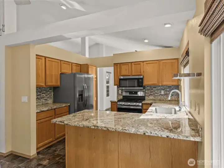 The roomy kitchen has stunning granite countertops.