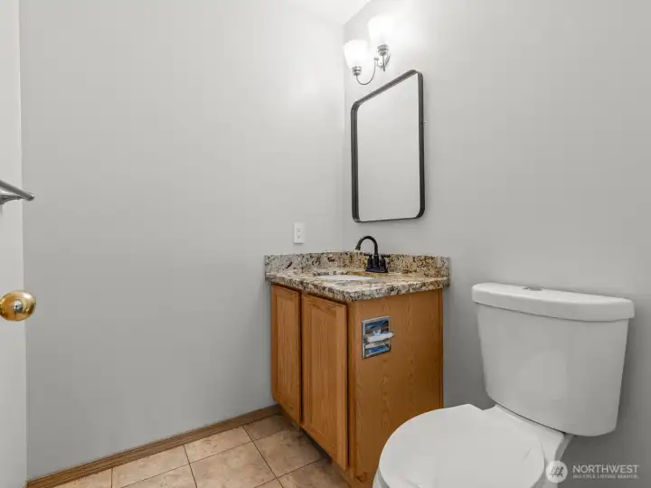 The conveniently located guest bathroom is just at the bottom of the stairs.