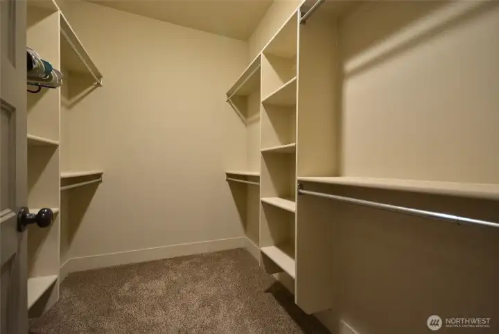 Huge walk-in closet with closet organizers.