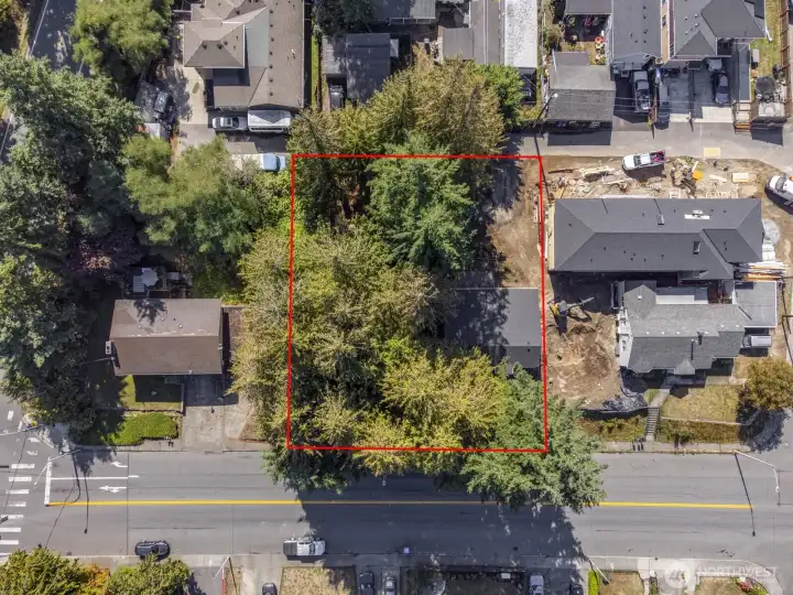 Two lots. One is vacant with trees, the other has a small post & pier rambler, 1200 sq. ft. Neighbor to the west is building a DADU.