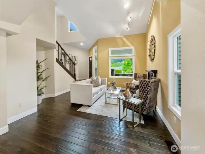 Living area with real wood floors off the entry looking from the separate dining area.