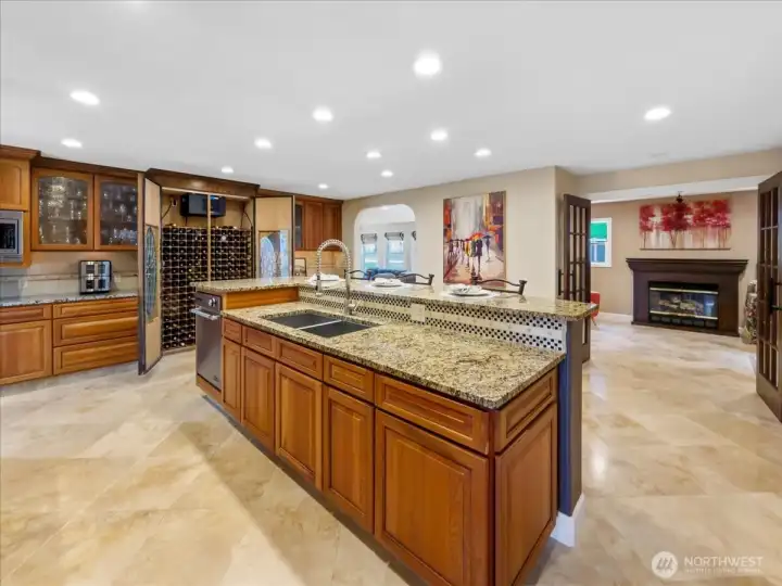 Large kitchen with eating space, custom built-in wine cabinet, and travertine floors.