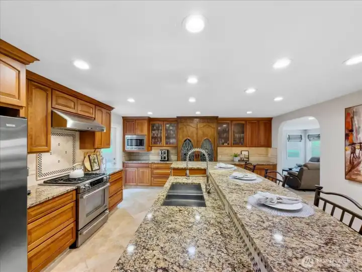 Large kitchen with eating space, custom built-in wine cabinet, and travertine floors.
