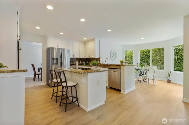 Kitchen with island and eating area opened to the patio and back yard. French door refrigerator complete an all stainless steel appliances set.
