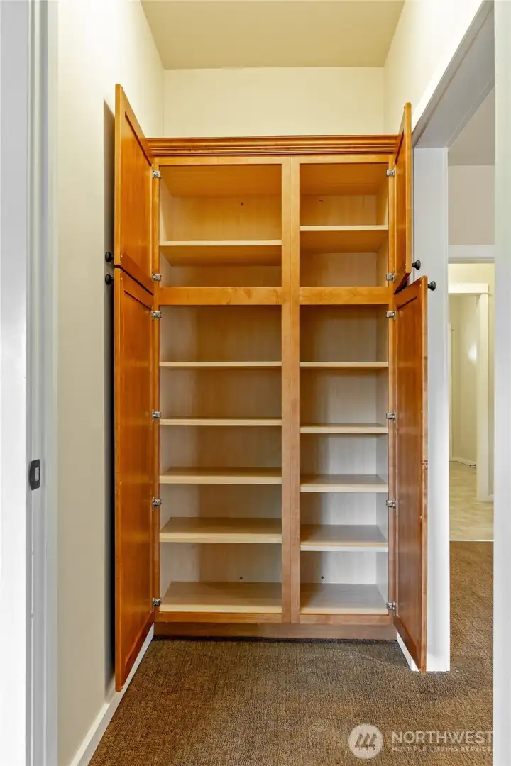 Large storage unit in hallway outside primary bedroom