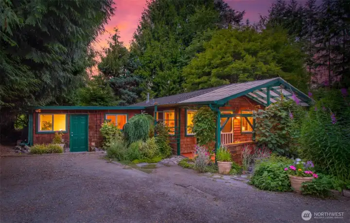 Gravel driveway leads to parking in front of the garden cottage