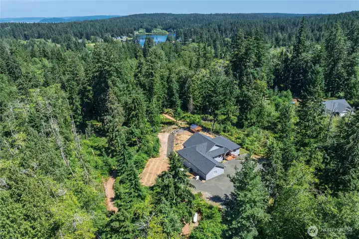 Aerial view of property. Bottom center is a 500-gallon (owned) propane tank used to power the Generac 22kW whole house generator. The groomed trail begins near the propane tank and is the light brown path furthest left in the photo. It meanders through the trees around backside of property up to the fenced-in/gated backyard. Aerial view of property. Bottom center is a 500-gallon (owned) propane tank used to power the Generac 22kW whole house generator. The groomed trail begins near the propane tank and is the light brown path furthest left in the photo. It meanders through the trees around backside of property up to the fenced-in/gated backyard.