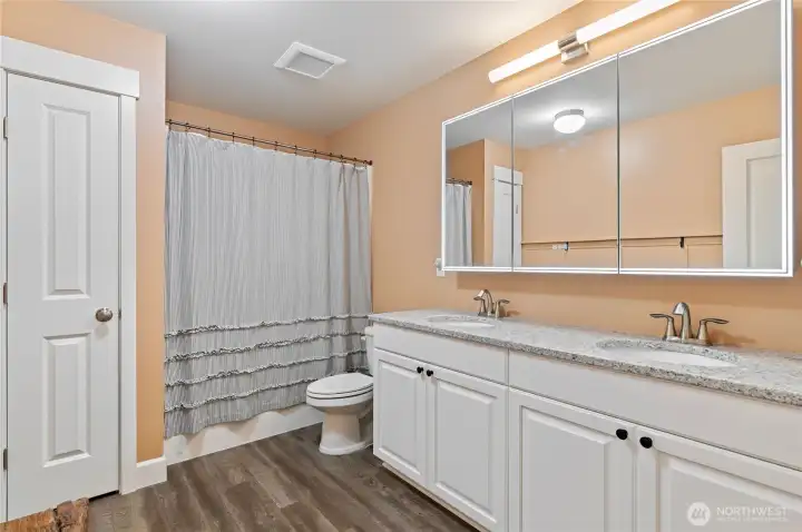 Hallway bathroom with linen closet, double sink, quartz counter, and a smart LED bathroom mirror. Hallway bathroom with linen closet, double sink, quartz counter, and a smart LED bathroom mirror.
