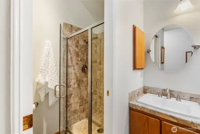 Separate shower with custom tile work and water closet.
