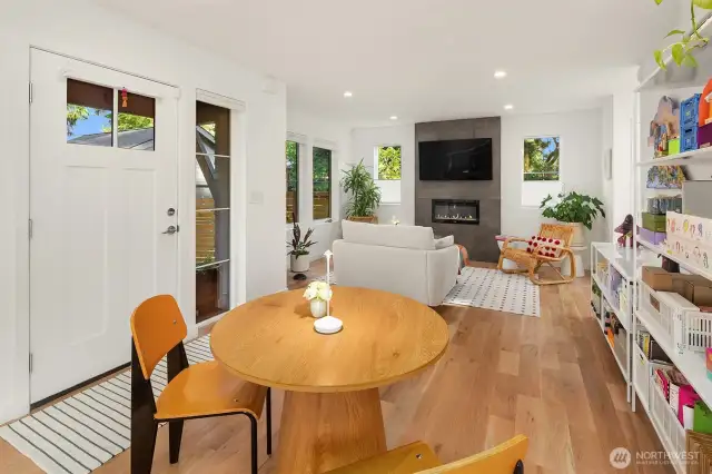 Gorgeous white oak floors and elegant fireplace anchor this open concept living.