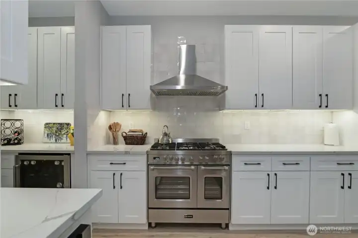 Gourmet kitchen with 5-burner gas range/double oven, wine fridge, pantry, and ample counter space