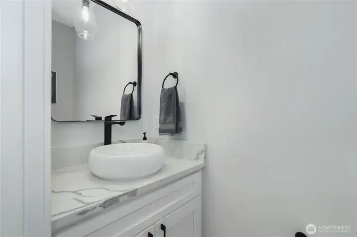 Powder room for guests is polished with custom accents
