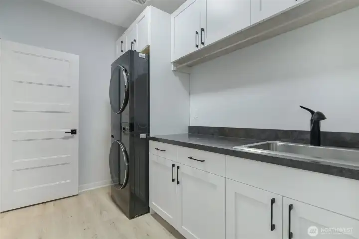 Laundry room with added storage, folding area, and sink - all appliances offered in sale