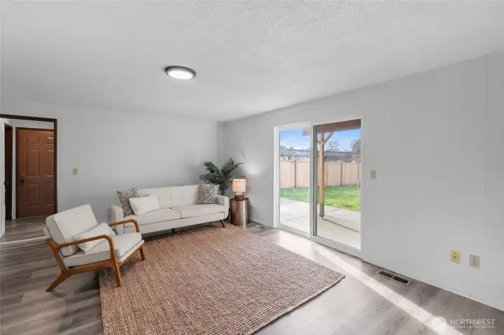 FAMILY ROOM | This comfortable room flows out onto the covered patio and big backyard. Notice the fresh paint and updated light fixture. Door pictured in left of photo leads to the outside. Not pictured is a door to the right that leads to the laundry/bathroom and door to the left that leads to the garage.