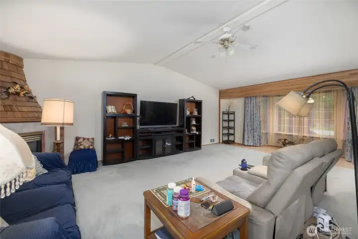 Spacious greatroom with bay window, vaulted ceilings, and gas firepace in the corner