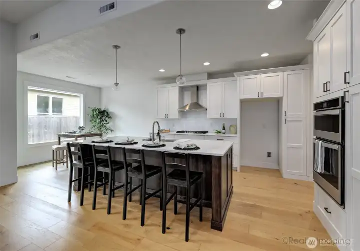 Kitchen, w/ 4-seat eat bar, quartz counters, engineered hardwood floors, built-ins and gas stove