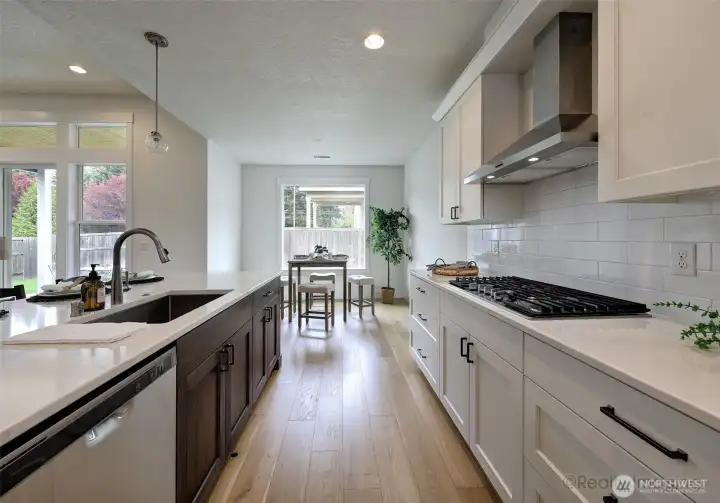 Kitchen, w/ 4-seat eat bar, quartz counters, engineered hardwood floors, built-ins and gas stove