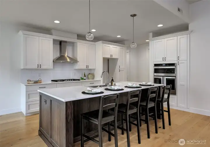 Kitchen, w/ 4-seat eat bar, quartz counters, engineered hardwood floors, built-ins and gas stove